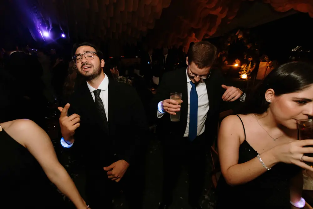 Invitados bailando bajo luces moradas