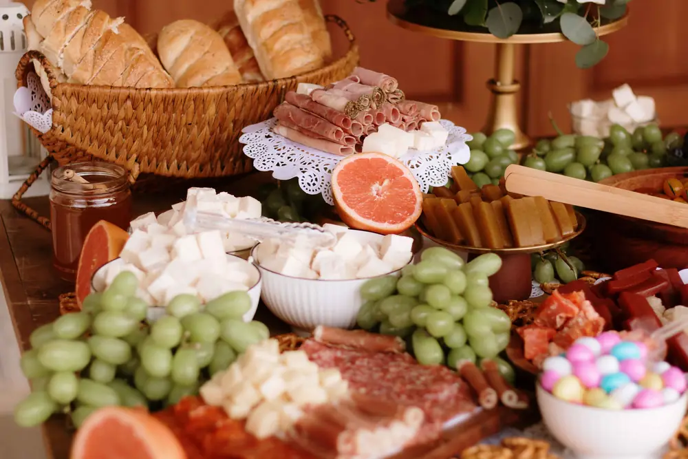 Mesa de quesos, carnes frías, uvas y pan artesanal